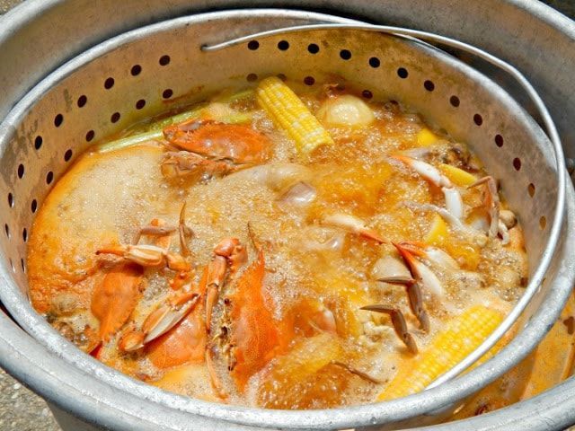 Boiling method for reheating cooked crab, with crab legs placed in a pot of boiling water for a few minutes to retain moisture and flavor.