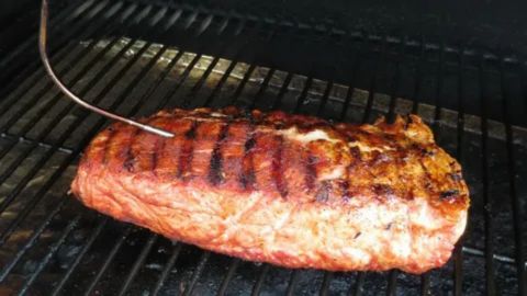 Grilling Smithfield pork tenderloin over medium-high heat with sear marks, cooked until tender and juicy for a smoky flavor