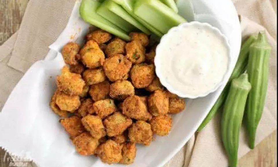 Crispy golden air-fried okra served in a bowl with grilled chicken and seafood, alongside breaded okra with dipping sauces such as ranch