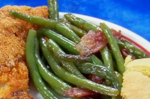 Bright green sautéed frozen green beans in a skillet with garlic and olive oil, shown tender-crisp beside a bowl of overcooked soggy beans for contrast.