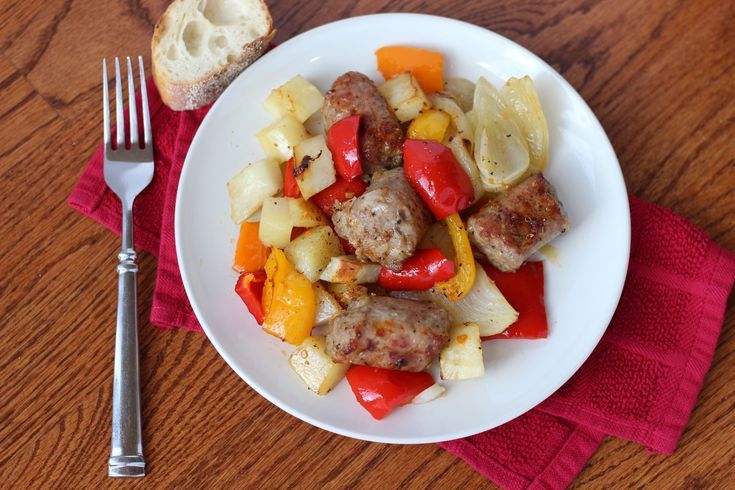 Golden-brown Italian sausages baking on a foil-lined sheet pan in the oven with roasted peppers and onions, checked with a thermometer at 160°F.”