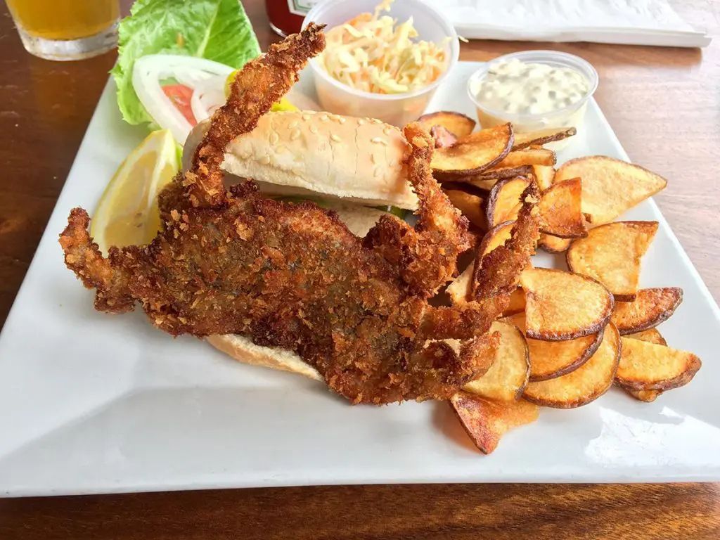 Informative table showing serving tips for reheated crab, including enhancers like butter, garlic sauce, and lemon; side dishes such as corn, potatoes, and salad; dipping sauces; and presentation ideas for a complete meal.
