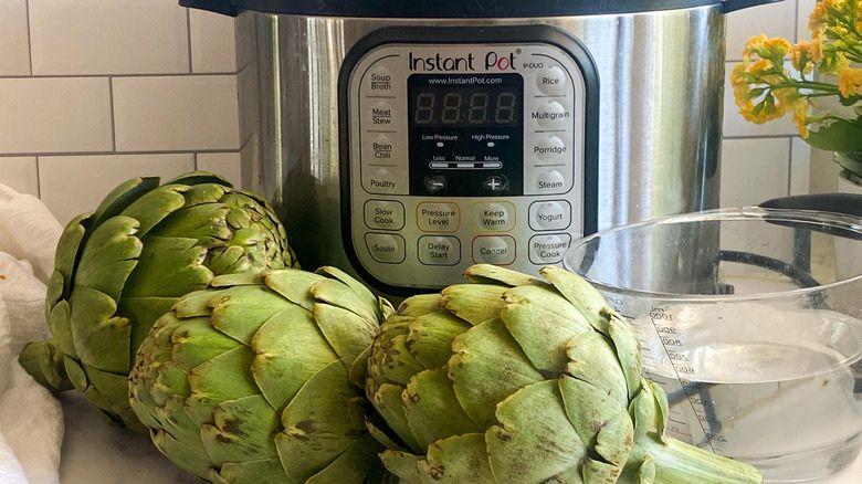Steamed artichokes in a pressure cooker highlighting quick and tender results.