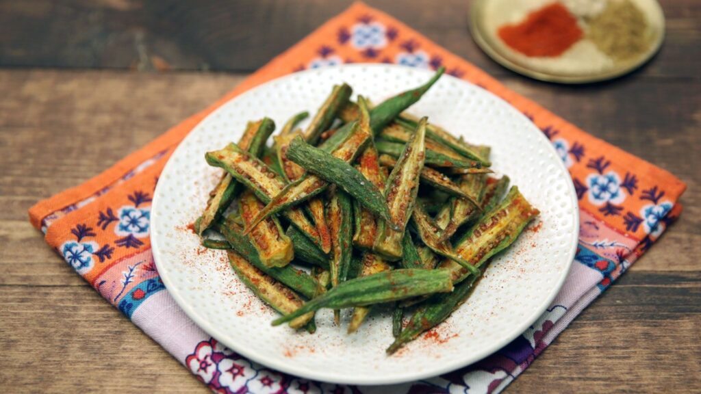 Crispy frozen okra cooked in an air fryer, served in a bowl with seasoning and parsley garnish, showing a healthy and flavorful side dish.”